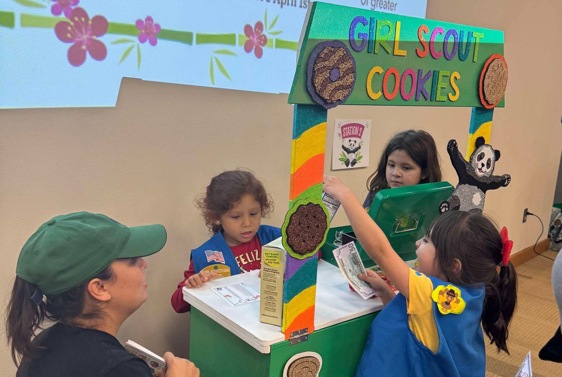 girl scout selling cookies with parent
