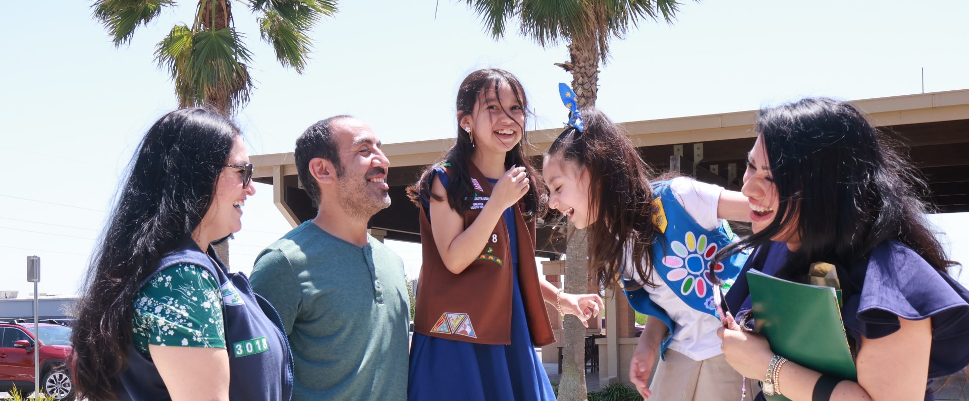  black family with mom, dad, and young daughter outside smiling 